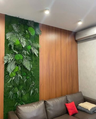 Moos- und Pflanzenpaneele an den Wänden im Wohnzimmer mit grauem Sofa