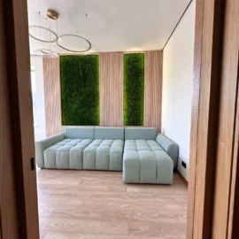 Paneele aus Flachmoos mit Beleuchtung und Leisten an den Wänden im Innenraum des Wohnzimmers mit hellem Sofa und Leisten