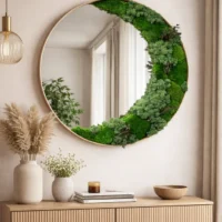 Moderner runder Spiegel mit Naturmoos und Pflanzen über einer Holzkommode im stilvollen Wohnzimmer-Interieur.