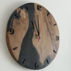 Schwarze Wanduhr aus Holz und Epoxid mit schwarzen Ziffern und rotem Sekundenzeiger in Seitenansicht