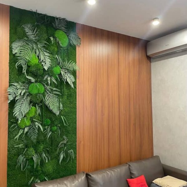 Moos- und Pflanzenpaneele an den Wänden im Wohnzimmer mit grauem Sofa